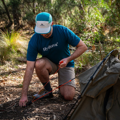 Orange Hydrava camping tensioner clipped to a guy rope on a swag tent.